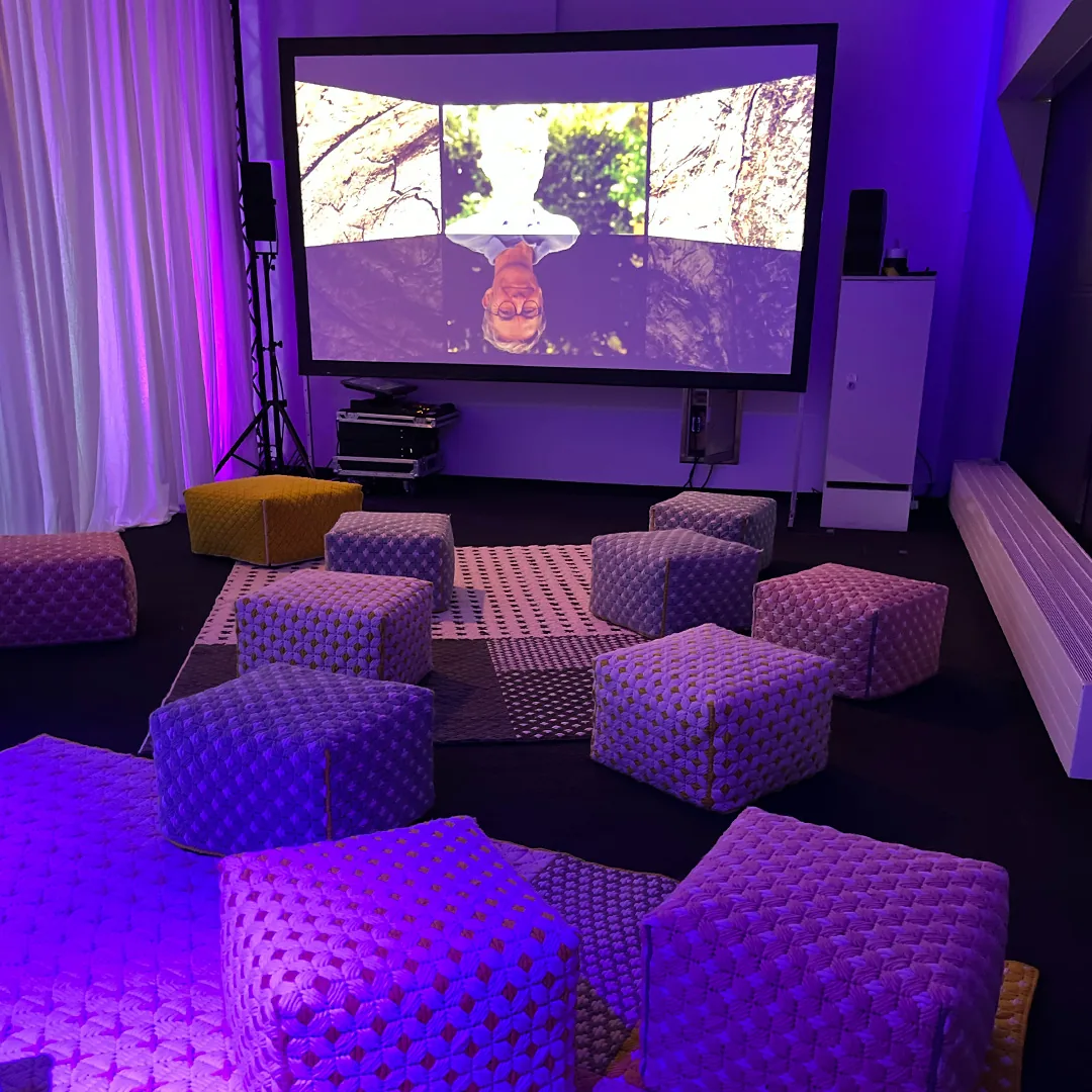 Sitzwürfel vor der Leinwand mit VR-Aufnahme auf dem Pflegetag